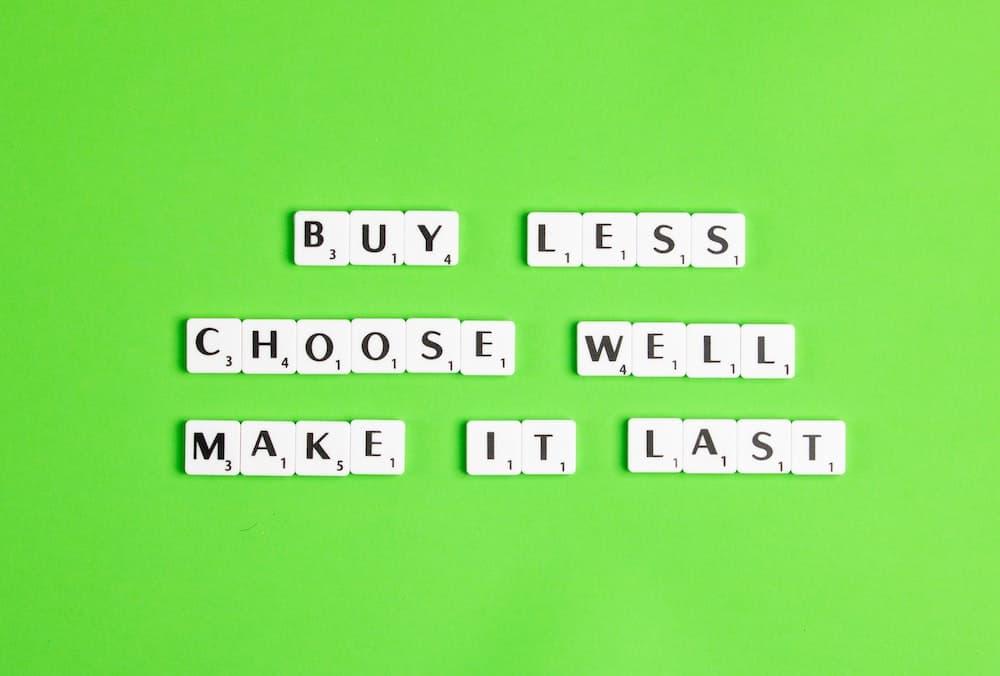 Quote in scrabble letters reading "Buy less. Choose well. Make it last."